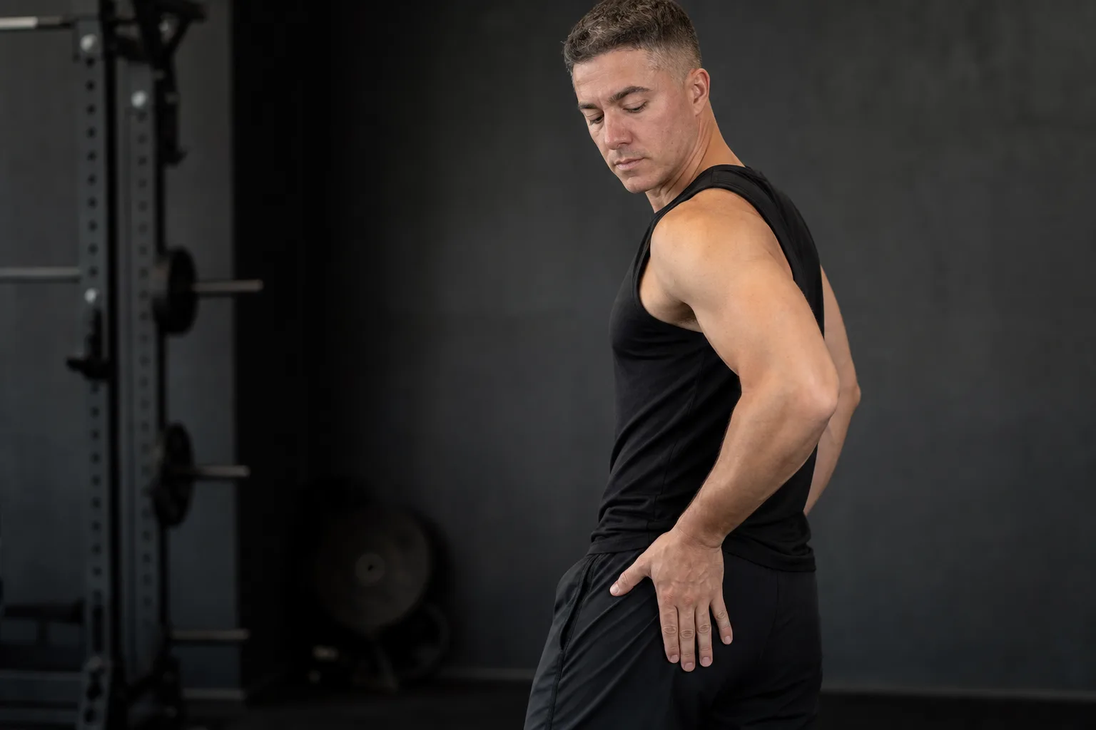 An athletic man holding the outside of his hip after developing lateral hip pain.